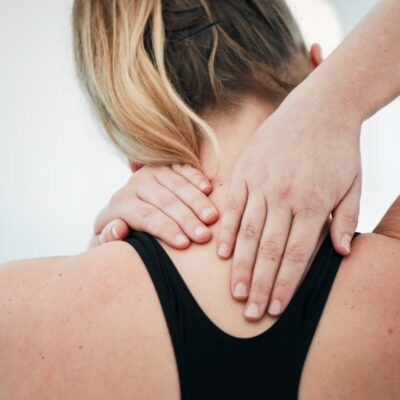 Kobieta masuje kark, odczuwając bóle stawów.