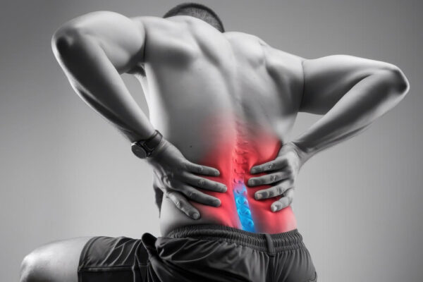 Mężczyzna trzyma się za dolną część pleców z powodu bólu spowodowanego dyskopatią.