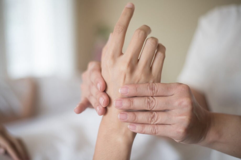 Osoba masuje dłoń, aby złagodzić drętwienie rąk.
