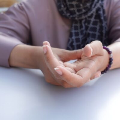 Osoba trzyma rękę, doświadczając drętwienia rąk.